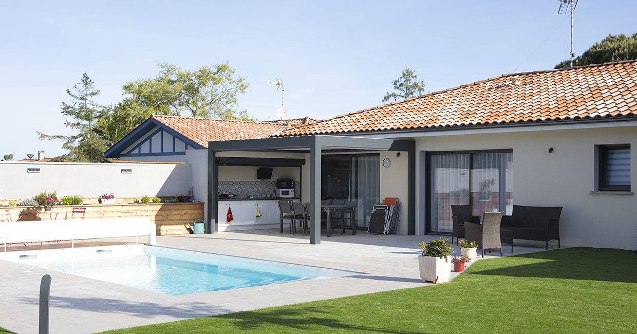 Terrasse couverte d'une maison moderne avec piscine dans les Landes