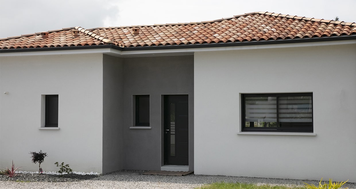 Entrée d'une maison contemporaine avec enduit bicolore et toiture 4 pans