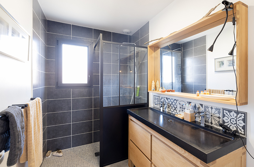 Salle de bain moderne avec faïence grise et meuble bois