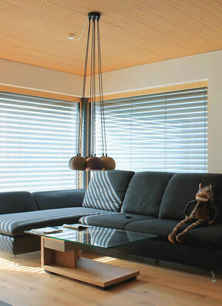 Intérieur d'une maison bois avec un canapé e un lustre contemporain