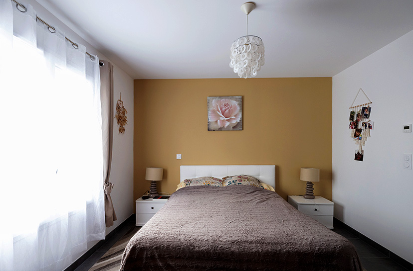 Chambre parentale avec un mur de couleur dans une maison moderne à Pontonx