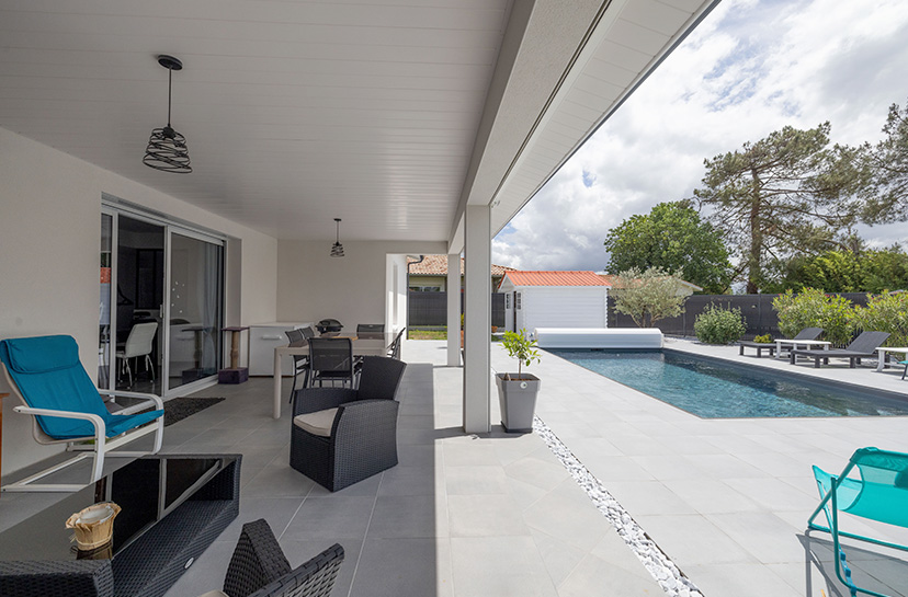 Terrasse couverte avec salon de jardin d'une maison moderne à Pontonx