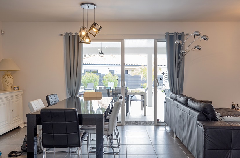 Salon avec baie vitrée à galandage dans une maison moderne à Pontonx