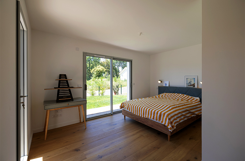 Chambre d'adulte avec baie vitrée et terrasse en bois