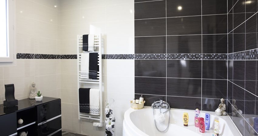 Belle salle de bain contemporaine avec baignoire d'angle et sèche serviettes