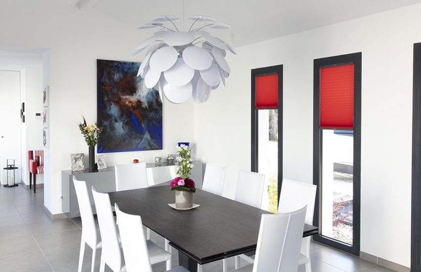 Salle à manger avec une table et ses fauteuils sous un lustre contemporain