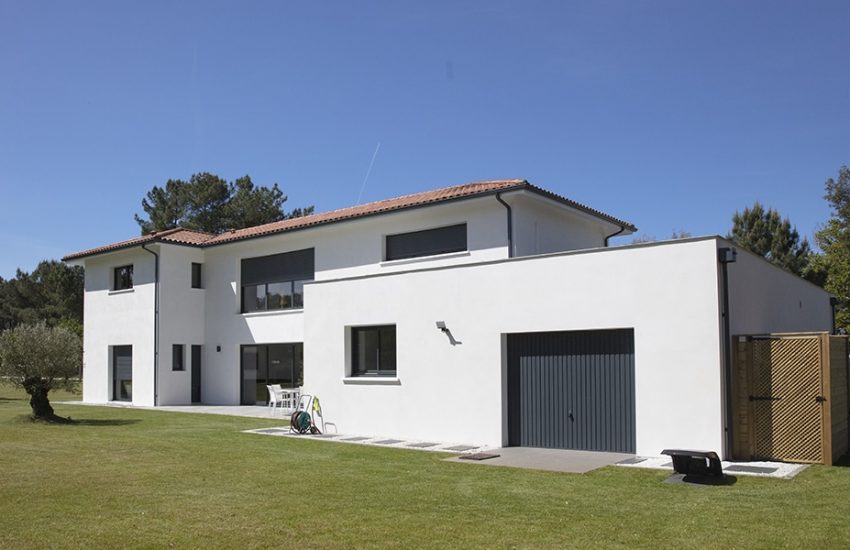 Garage moderne avec toit plat dans un jardin parfaitement entretenu