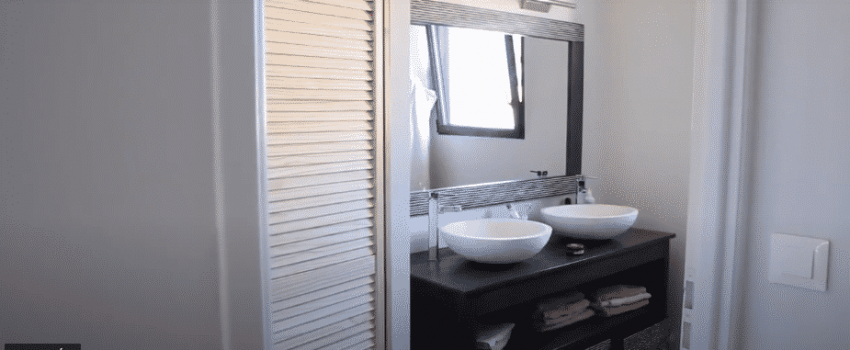 Salle de bain avec double vasque et grand miroir