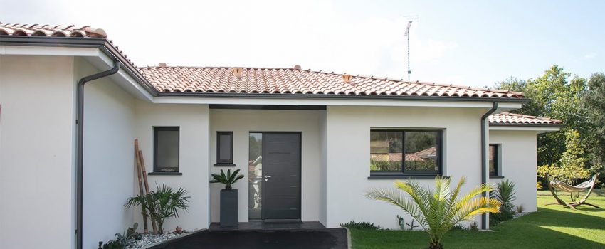 Entrée goudronnée et végétalisée d'une maison dans les Landes