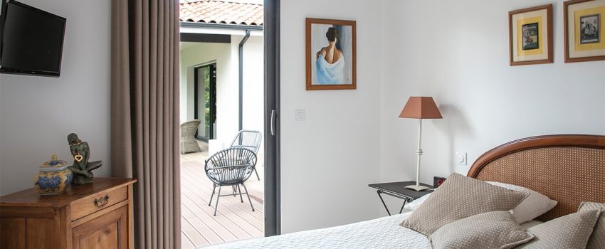 Chambre adulte avec porte fenêtre donnant sur terrasse