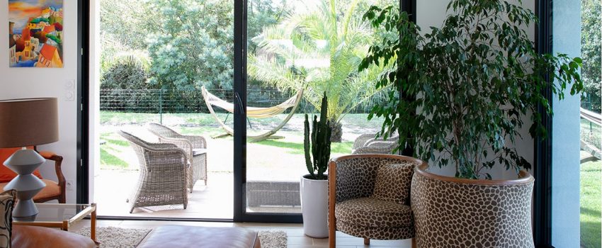 Salon avec grande baie vitrée donnant sur jardin