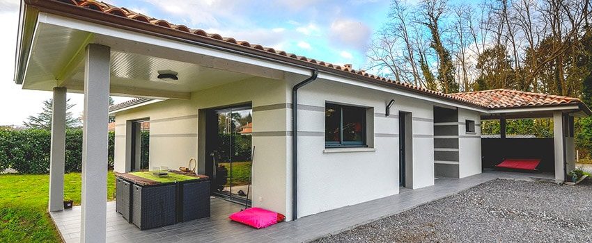 Maison contemporaine avec une terrasse couverte et un enduit bicolore